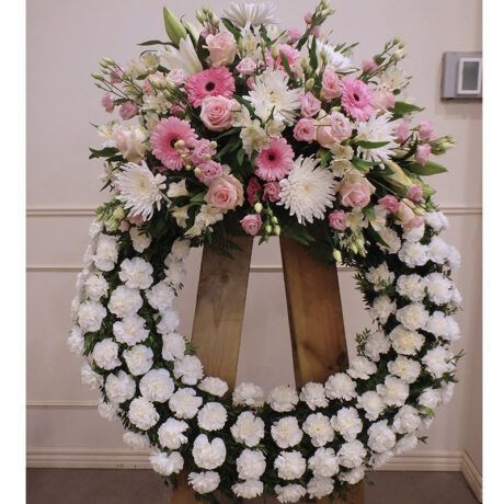 Corona floral en tonos blancos y presencia del rosa