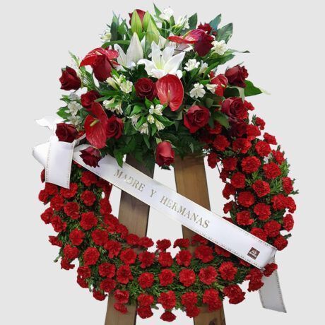 Elegante corona floral con predominio del rojo