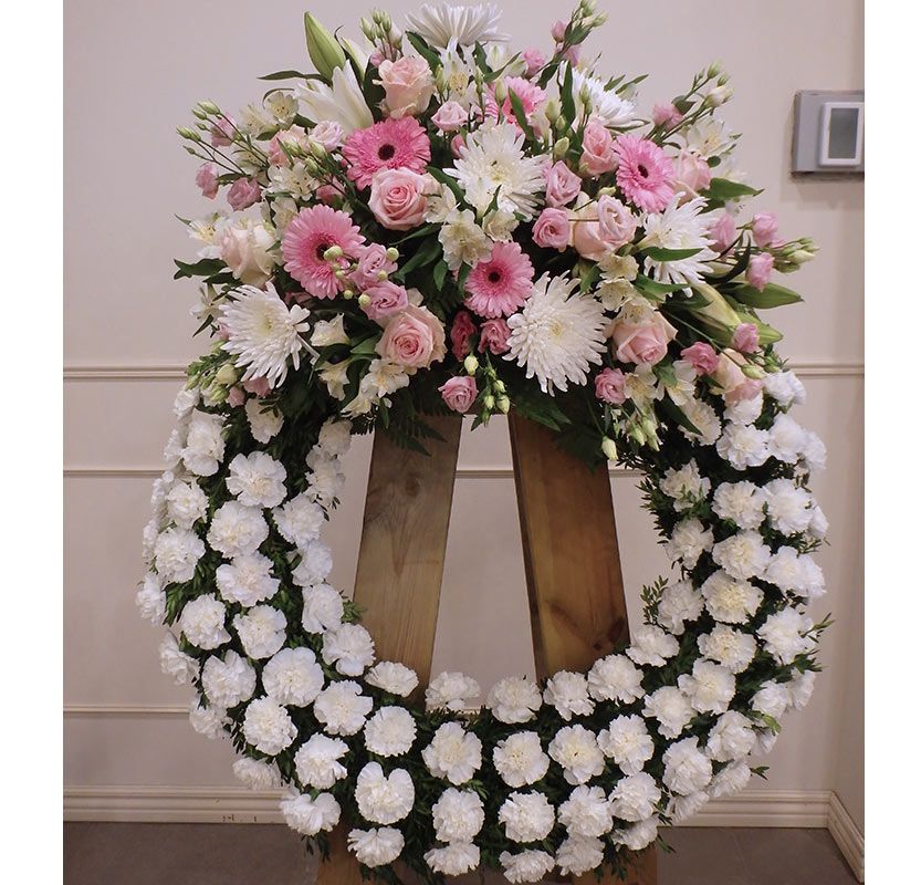 Corona floral en tonos blancos y presencia del rosa